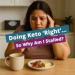Hispanic woman sitting at a kitchen table, looking frustrated while drinking bulletproof coffee and eating keto snacks, questioning why her keto weight loss has stalled.
