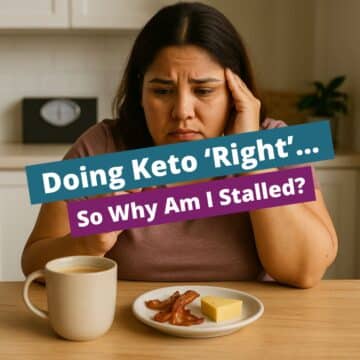 Hispanic woman sitting at a kitchen table, looking frustrated while drinking bulletproof coffee and eating keto snacks, questioning why her keto weight loss has stalled.